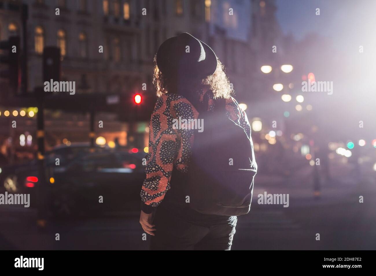 Rear view of woman on city street at night Stock Photo - Alamy