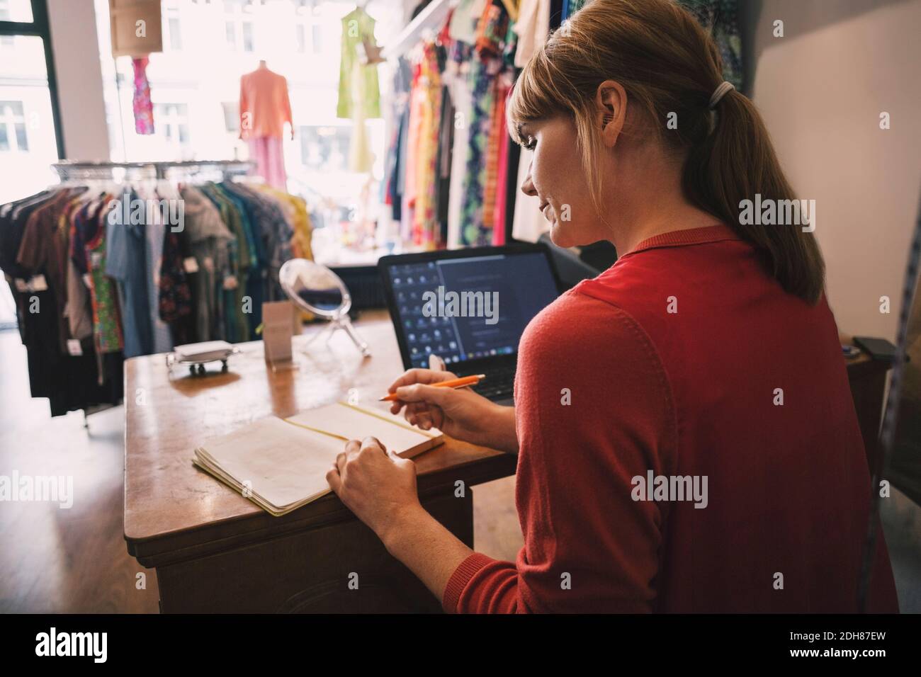 Owner working while sitting at desk in thrift store Stock Photo