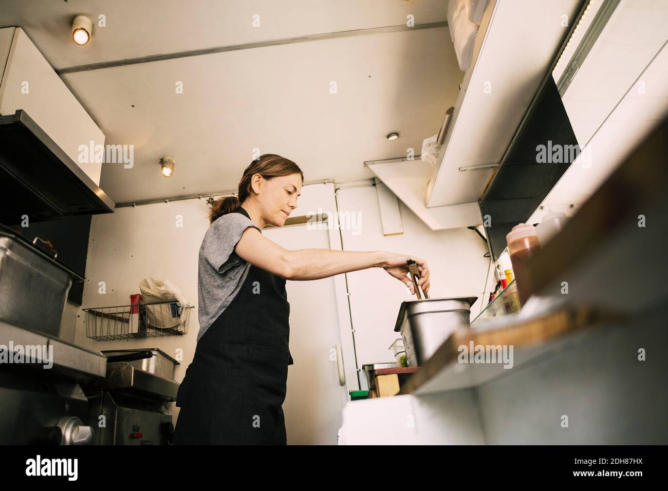 Low angle view of woman preparing food in truck Stock Photo