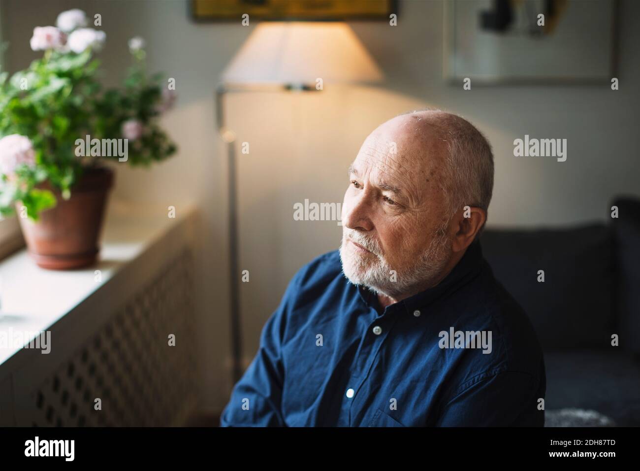 Thoughtful senior man looking away at home Stock Photo