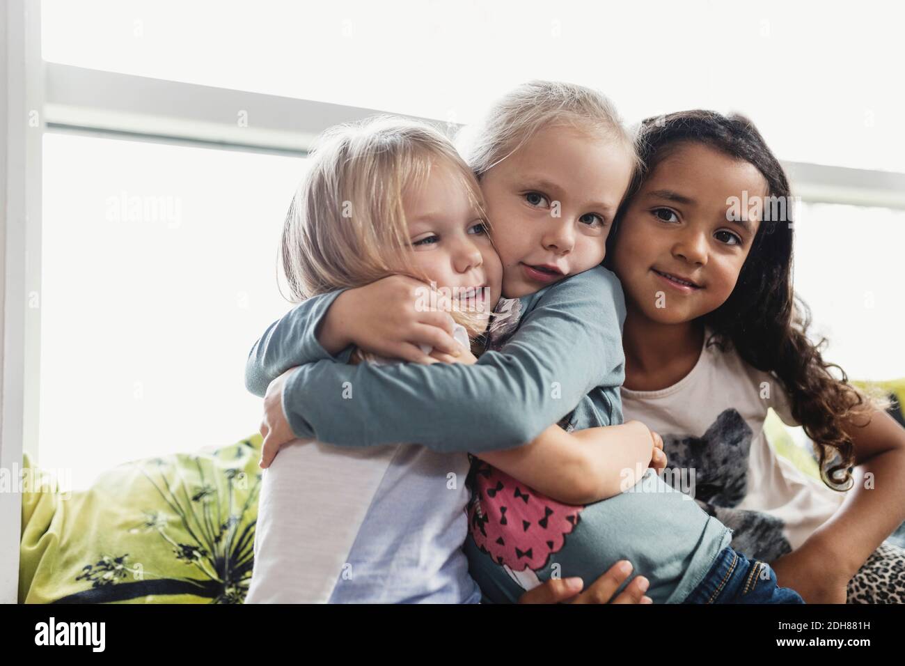 Portrait of girls embracing in day care center Stock Photo