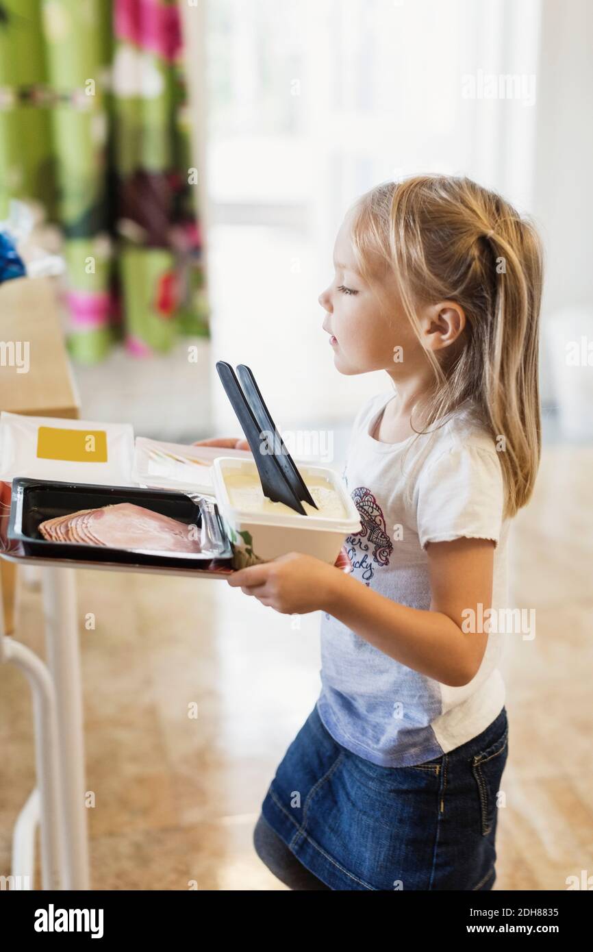 Girl carrying food in tray at preschool Stock Photo