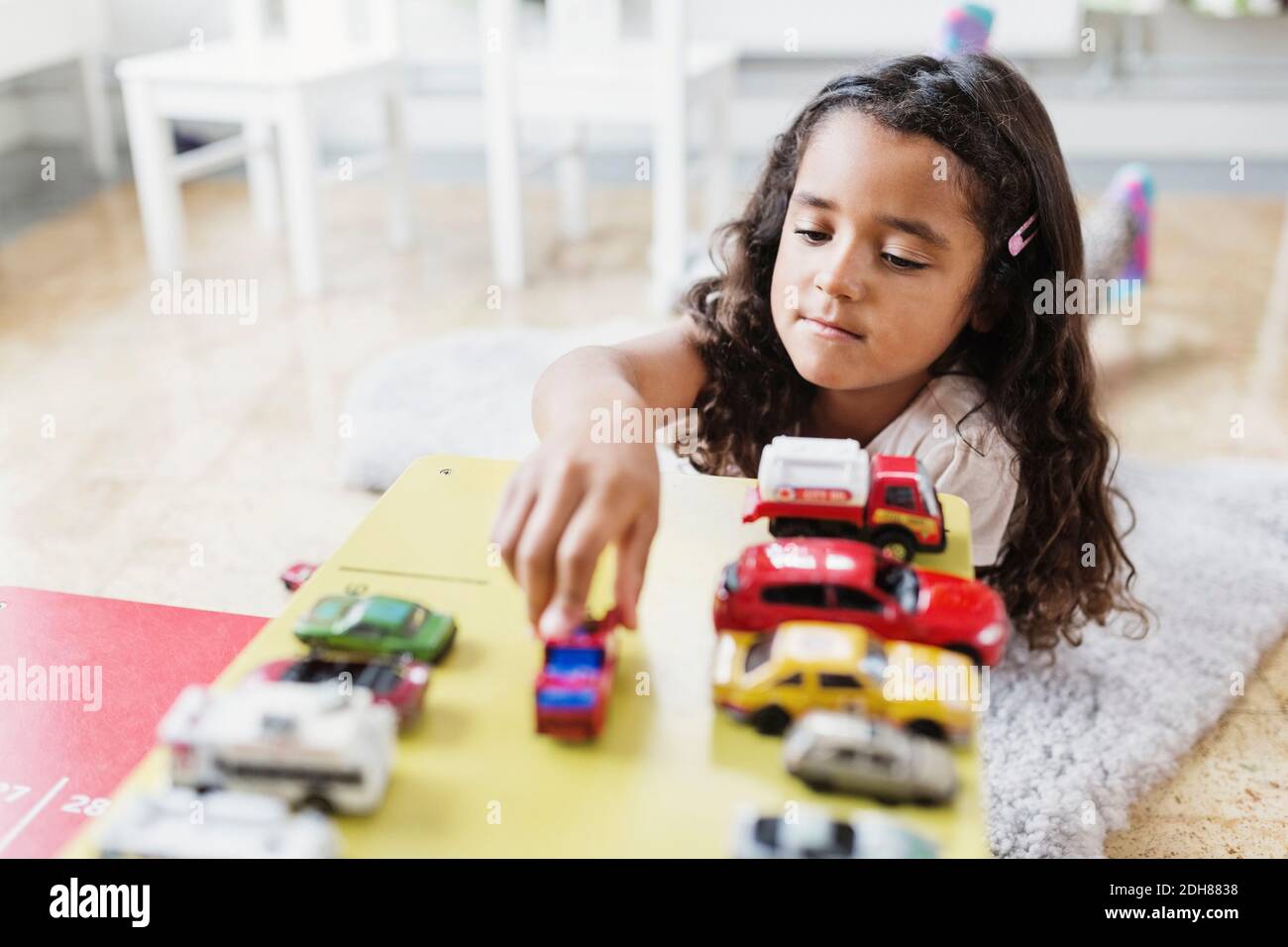 Little girl playing with toy car in day care center Stock Photo - Alamy
