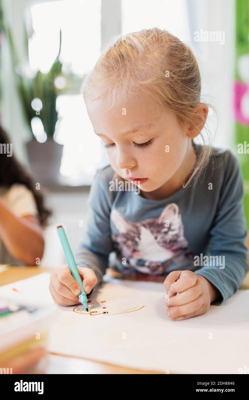 Girl using felt tip pen in drawing class Stock Photo