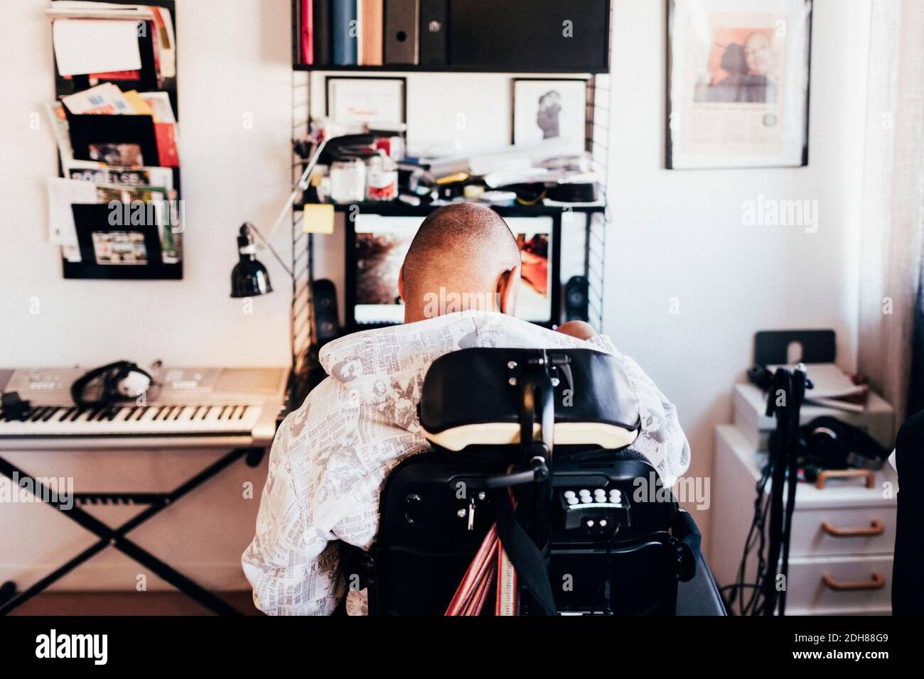 Rear view of disabled musician sitting on wheelchair in recording