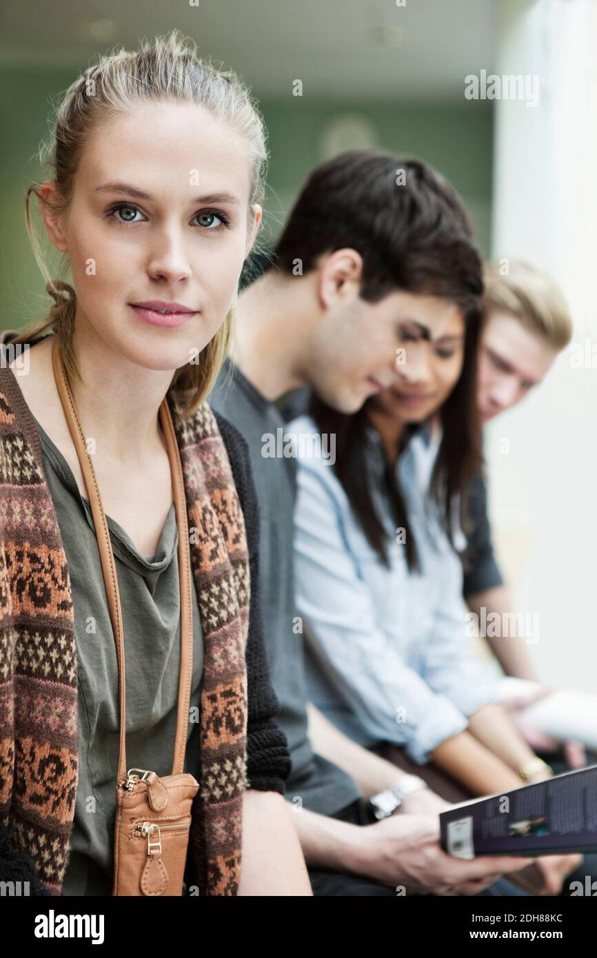 Portrait of beautiful young woman with friends in background Stock Photo