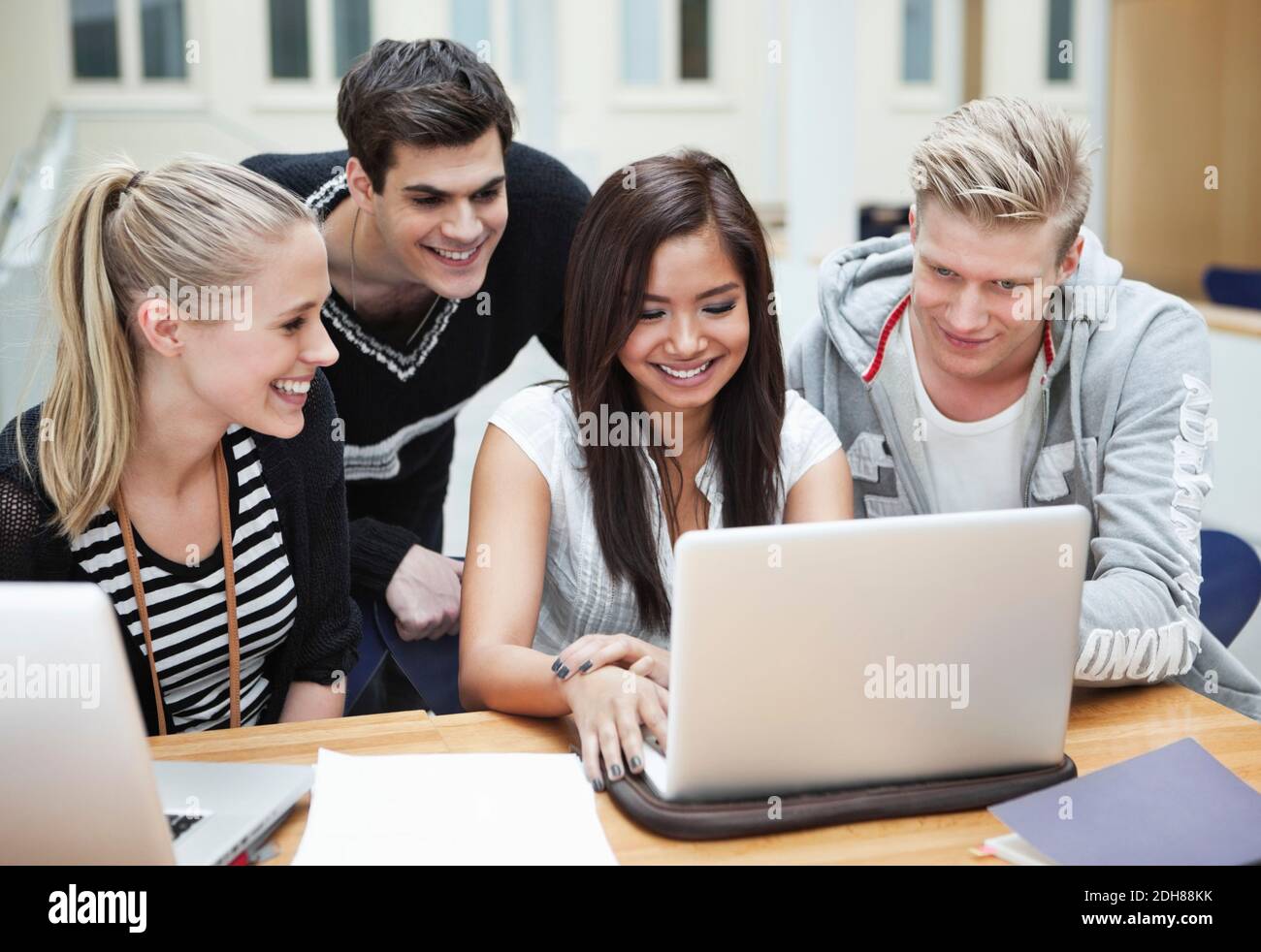 Young happy friends using laptop Stock Photo