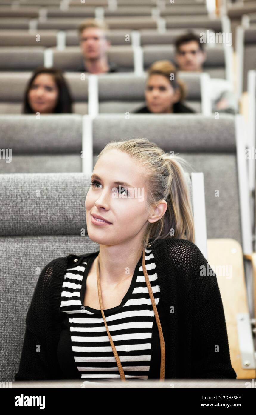 Close up of beautiful young woman sitting in auditorium Stock Photo