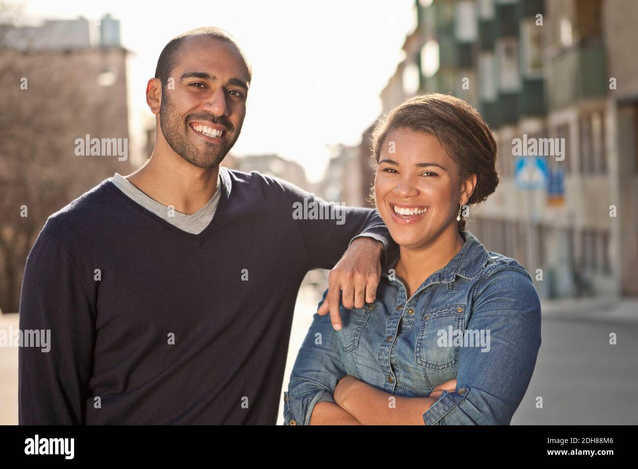 Front view portrait of male friend with arm on female's shoulder Stock Photo