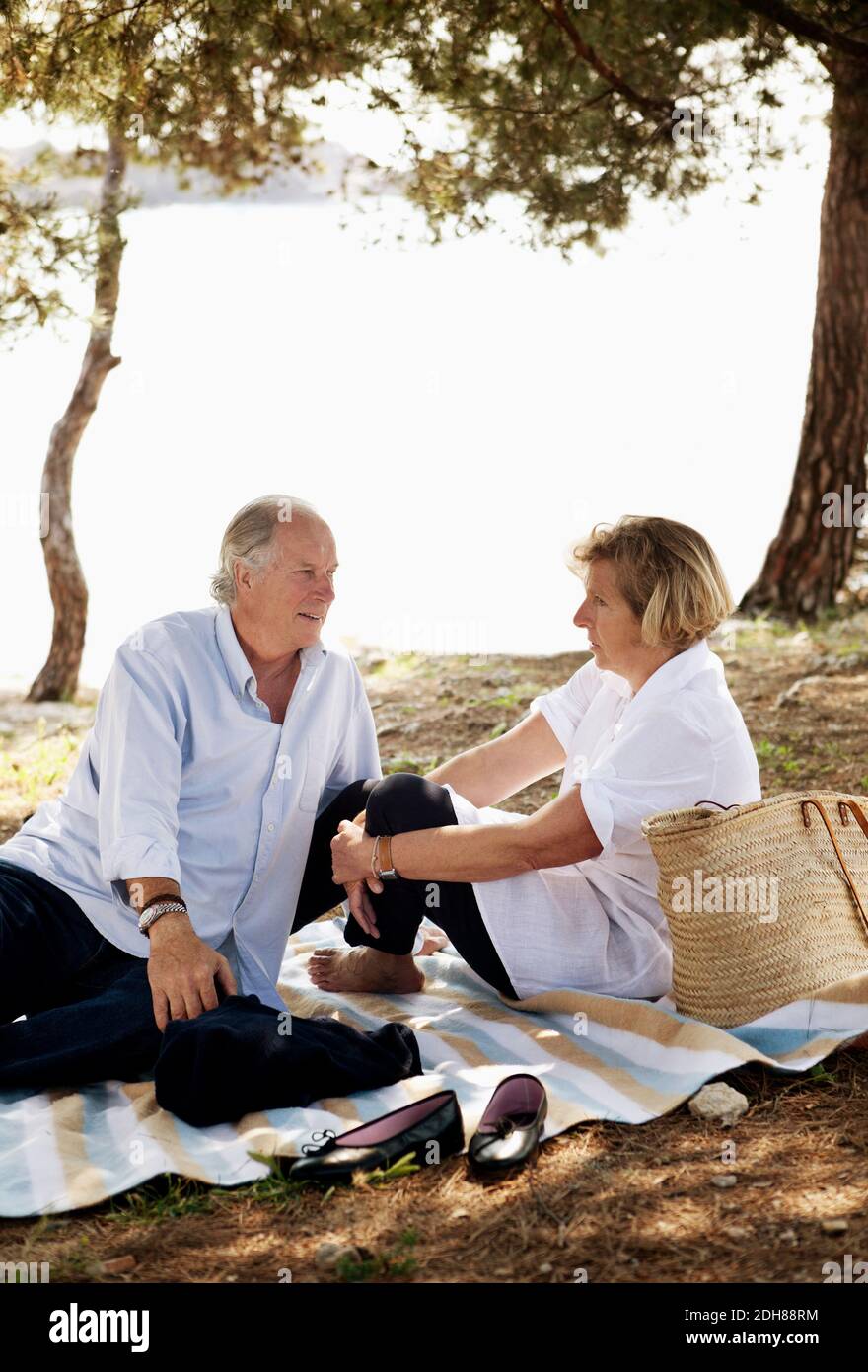Senior man and mature woman enjoying picnic together Stock Photo