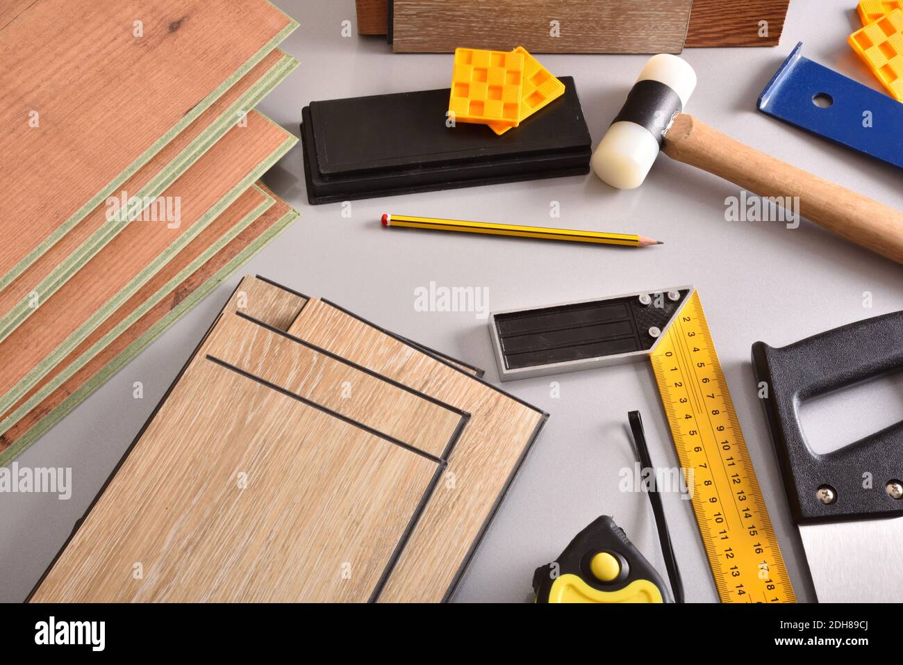 laminated flooring and assorted tools for placement on a gray table. Elevated view. Horizontal composition. Stock Photo