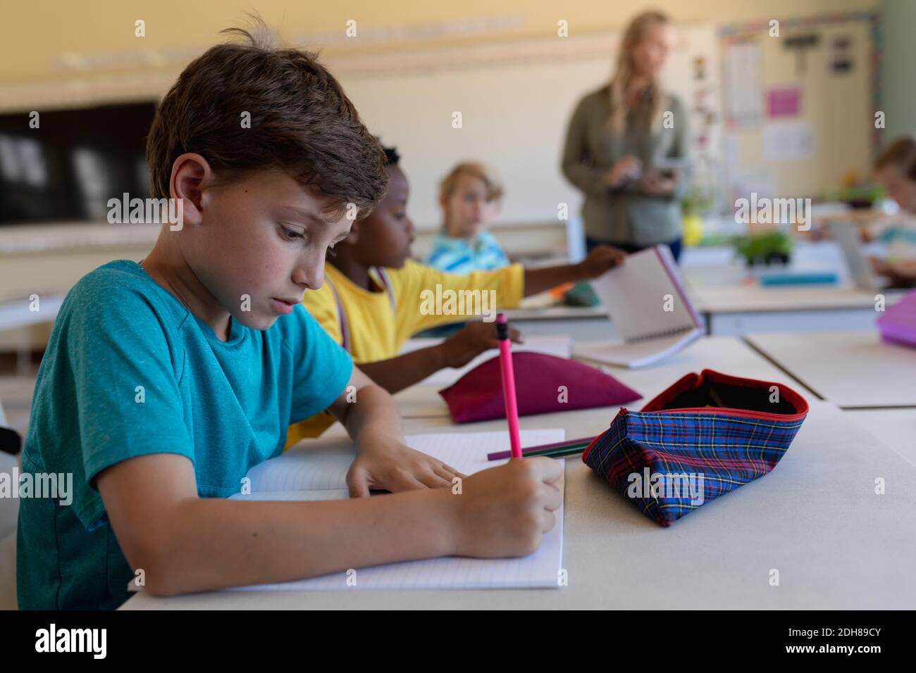 Schoolboy sitting at a desk in an elementary school classroom Stock ...