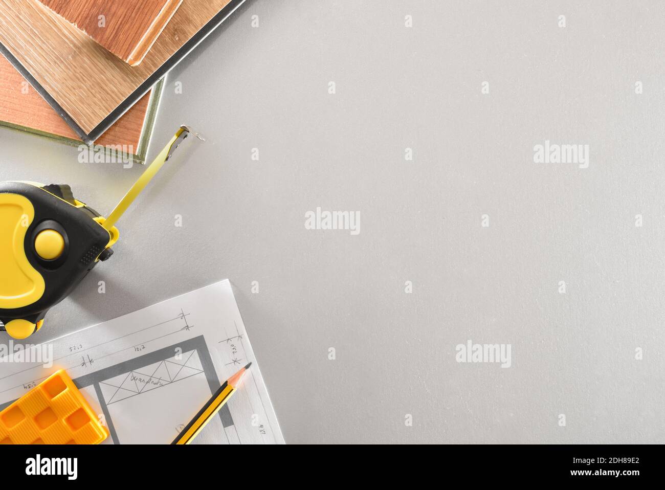 Detail of materials and tools on the work table of a parquet installer with plans. Top view. Stock Photo