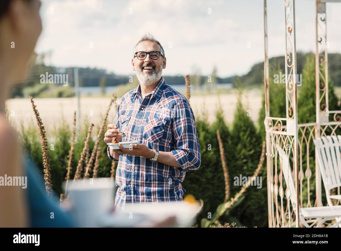 Happy mature man smiling at female friend in back yard Stock Photo