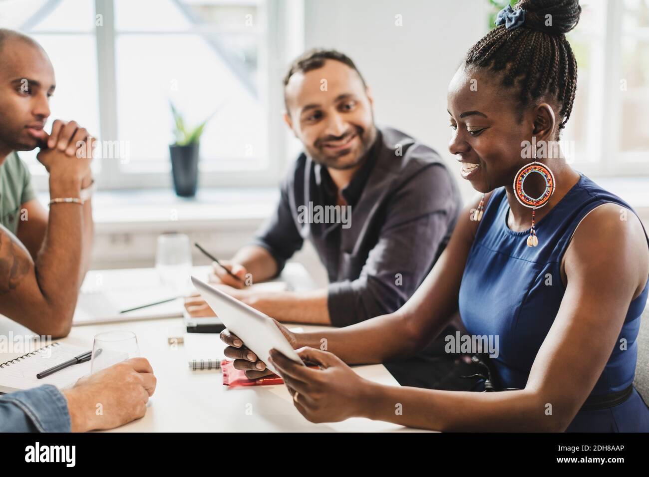 Friends looking at woman using digital tablet in language class Stock Photo