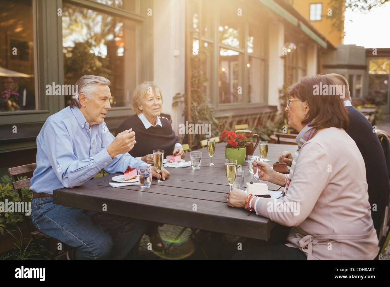 Two senior couples having desserts at outdoor restaurant Stock Photo