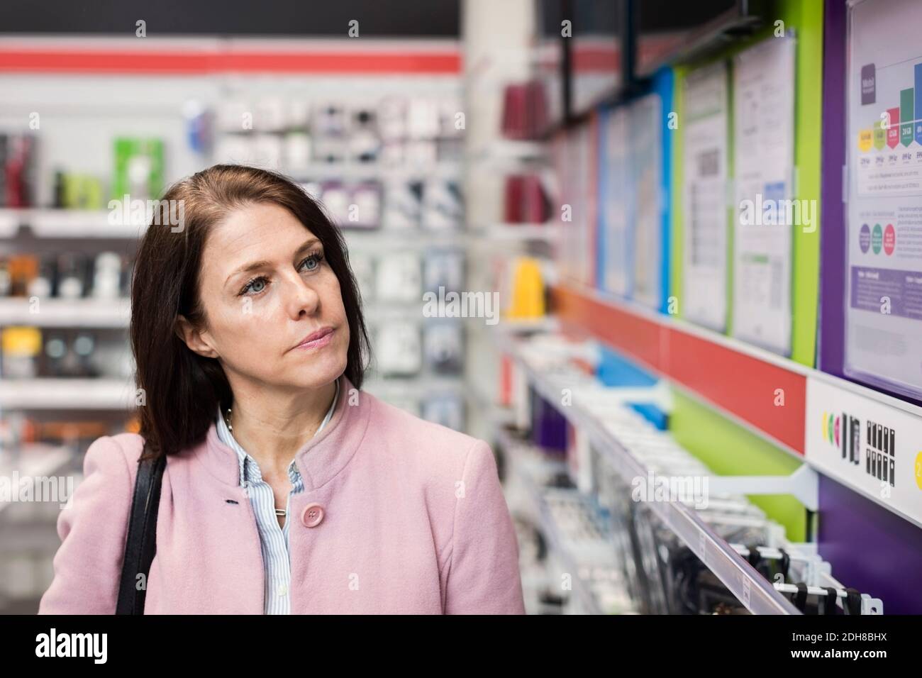 Female customer viewing technology in electronics store Stock Photo