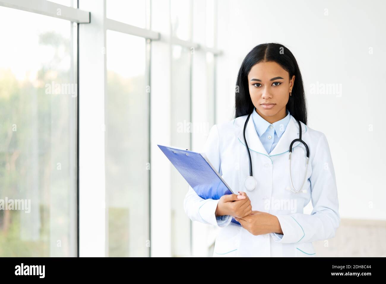 Beautiful confident african american doctor with clipboard in hospital Stock Photo