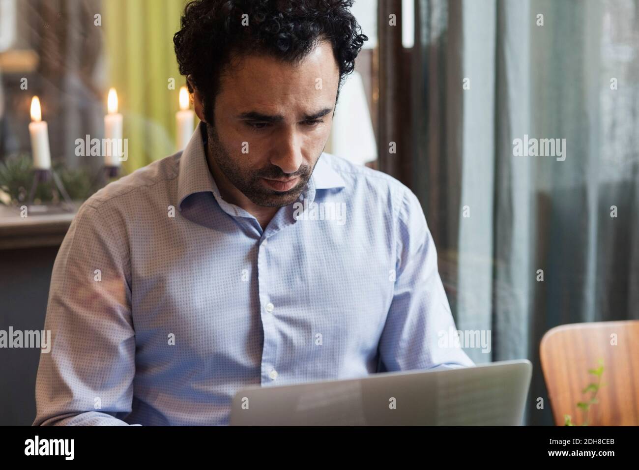 Concentrated blogger working on laptop in creative office Stock Photo