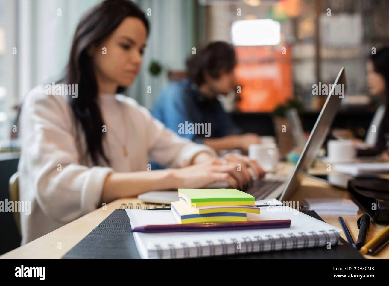 Close-up of office supplies with creative people working at table Stock Photo