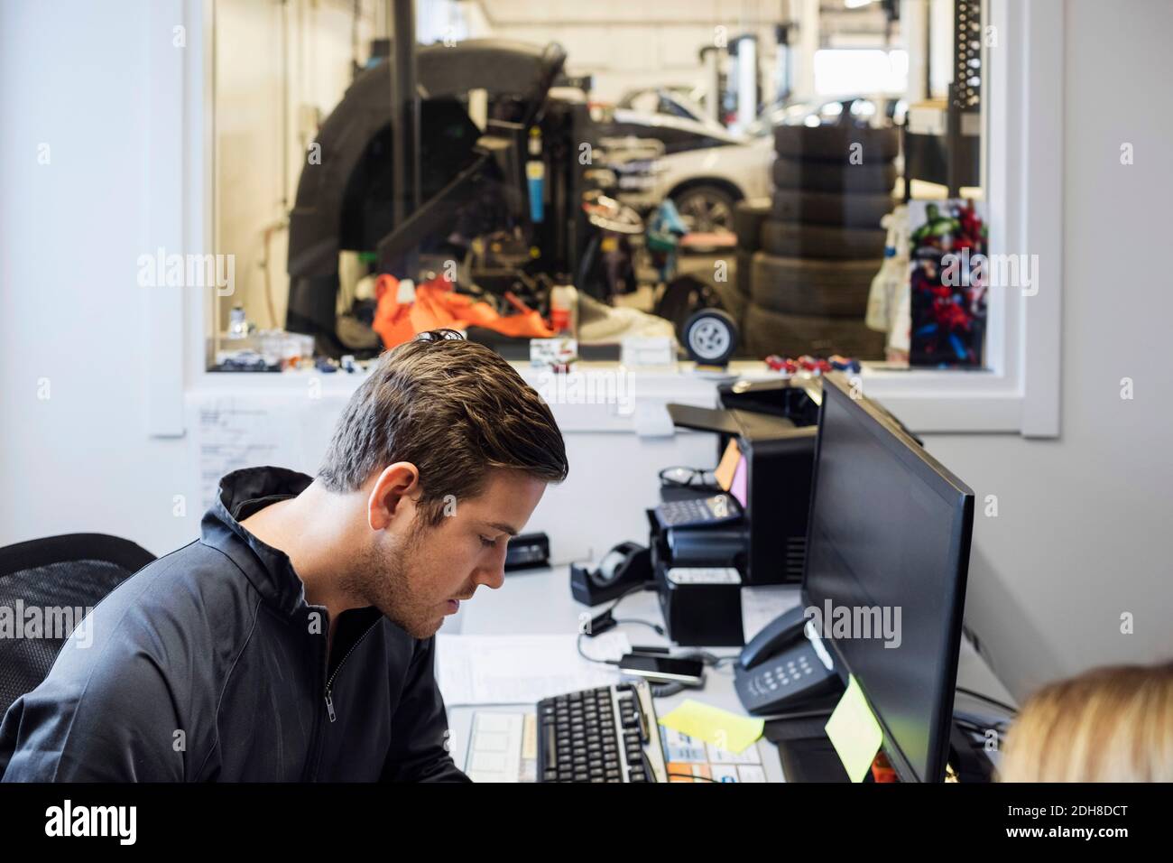 Serious owner sitting in office at auto repair office Stock Photo Alamy