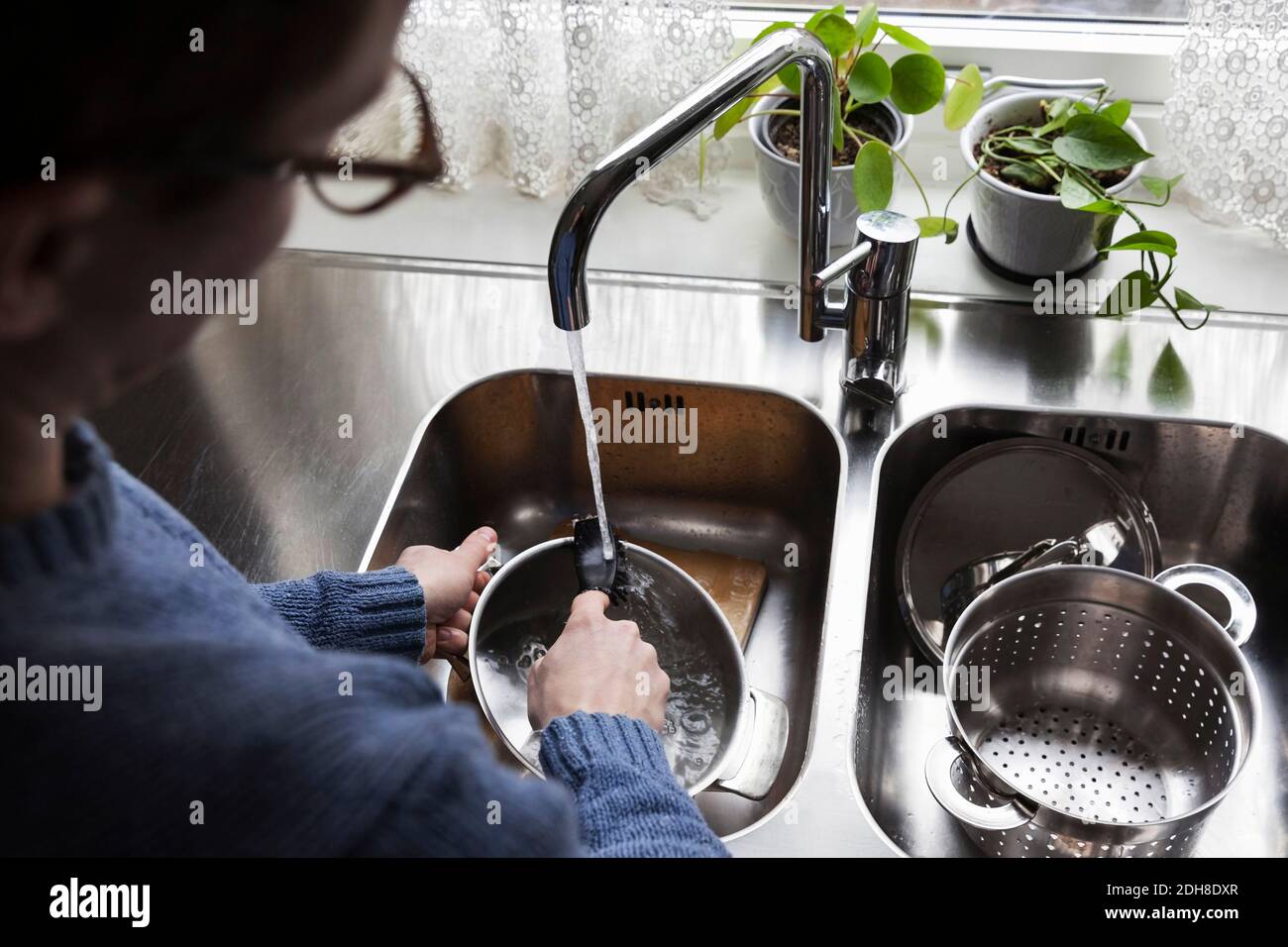 https://c8.alamy.com/comp/2DH8DXR/cropped-image-of-man-washing-utensils-at-kitchen-sink-2DH8DXR.jpg