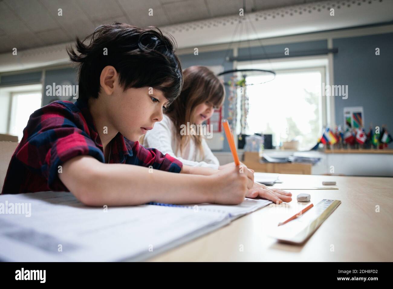 Serious students studying at desk in classroom Stock Photo