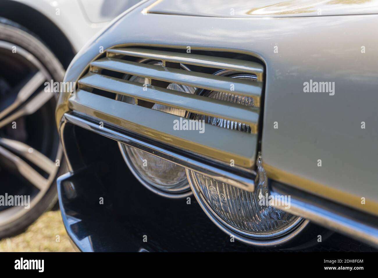 Close up detail of the pop up headlights on a classic gold Alfa Romeo