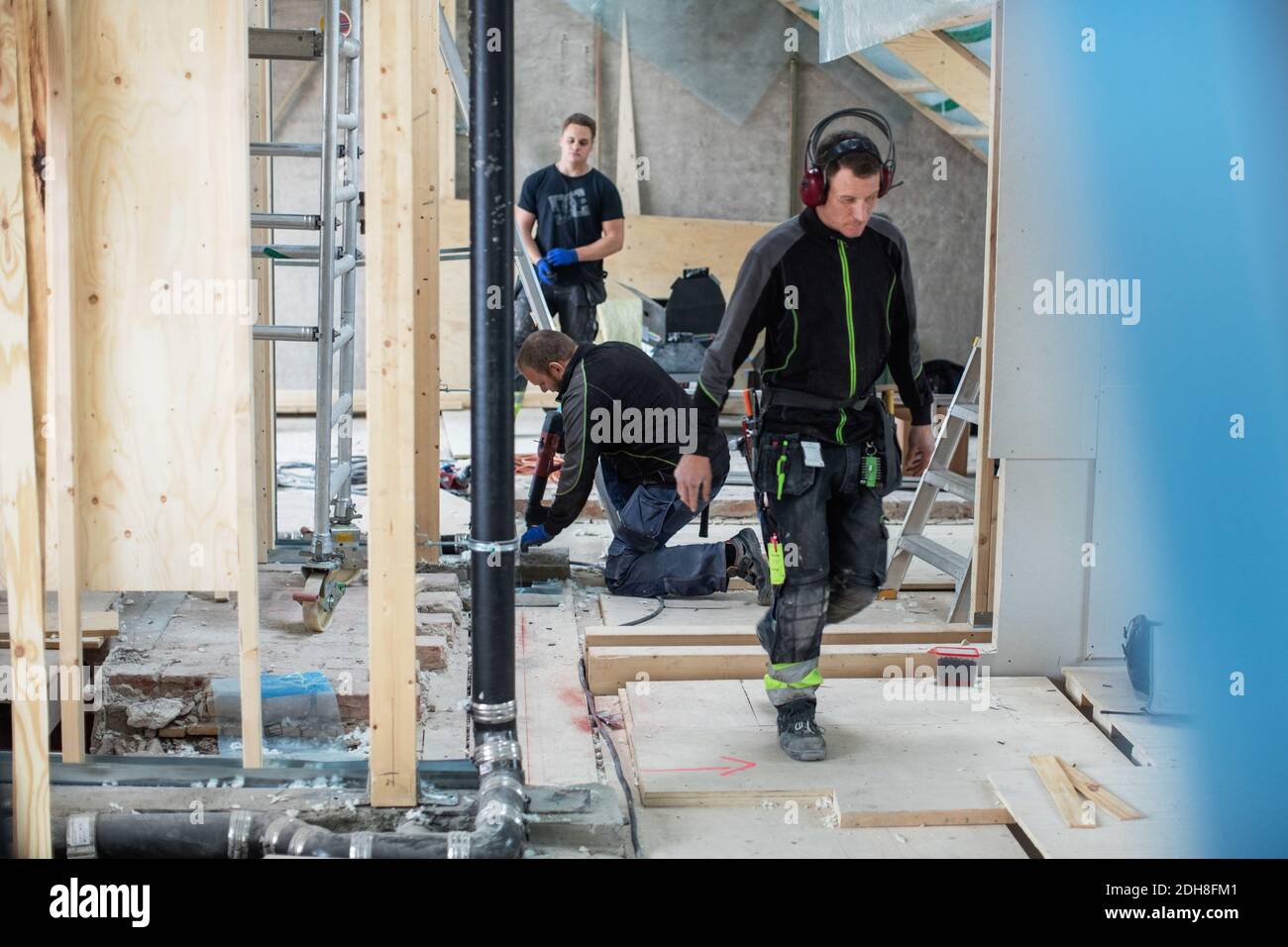 Manual workers working on messy floor at construction site Stock Photo