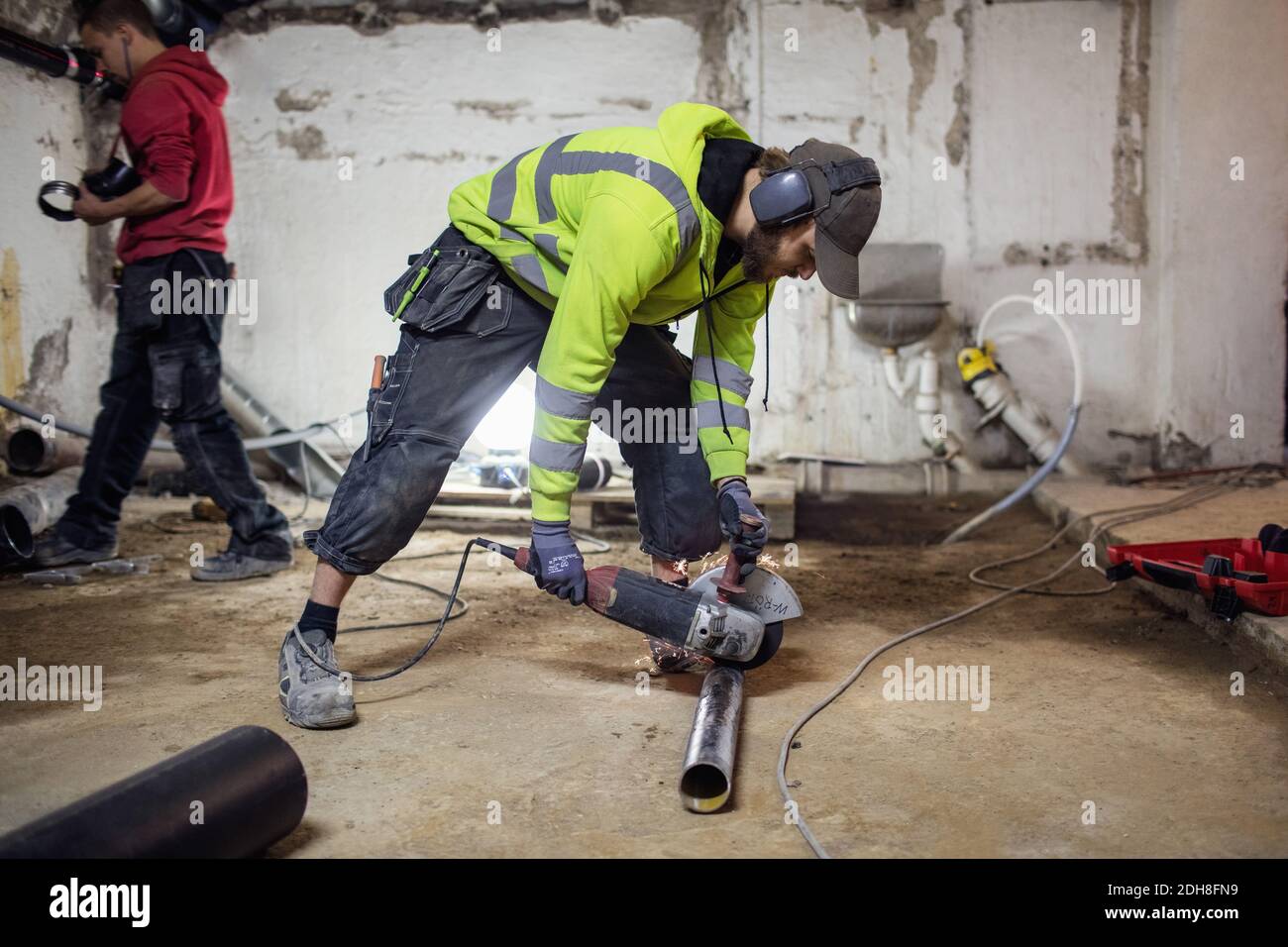 Plumbers working on pipes in abandoned basement Stock Photo