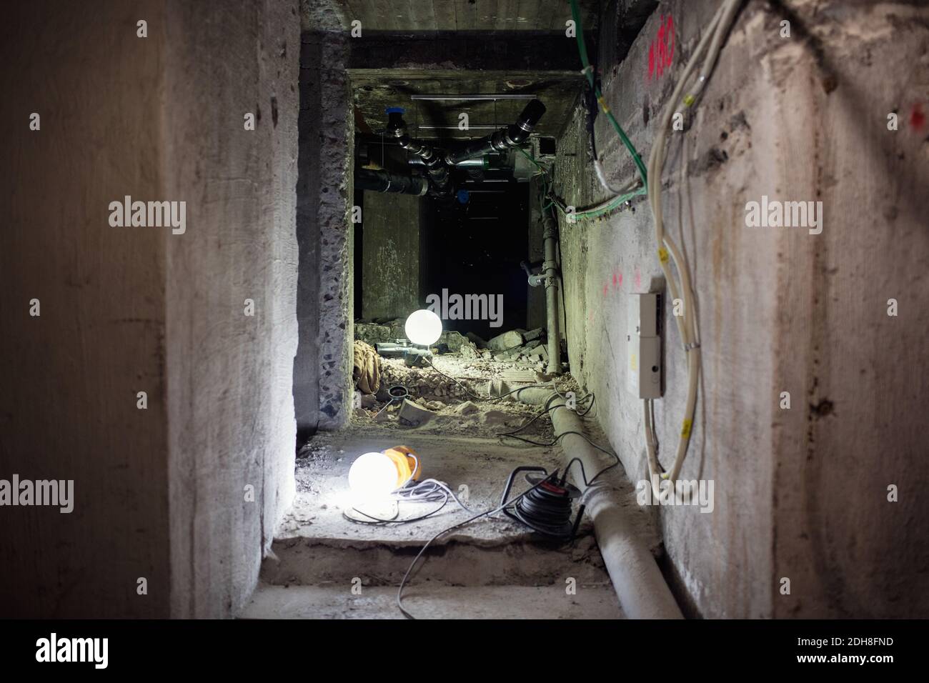 Illuminated lights on floor in messy corridor at construction site Stock Photo