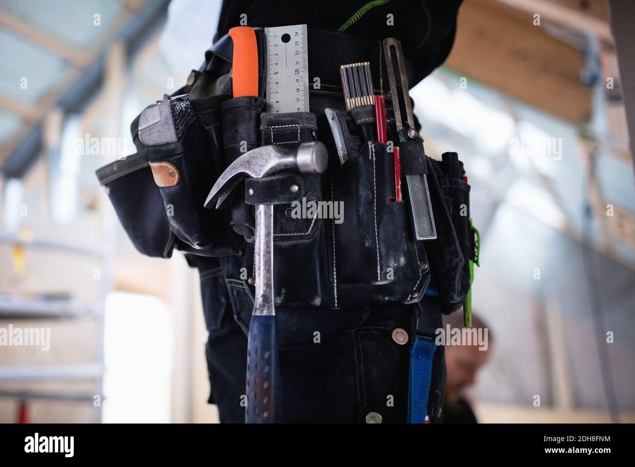 Midsection of construction worker wearing tool belt at site Stock Photo