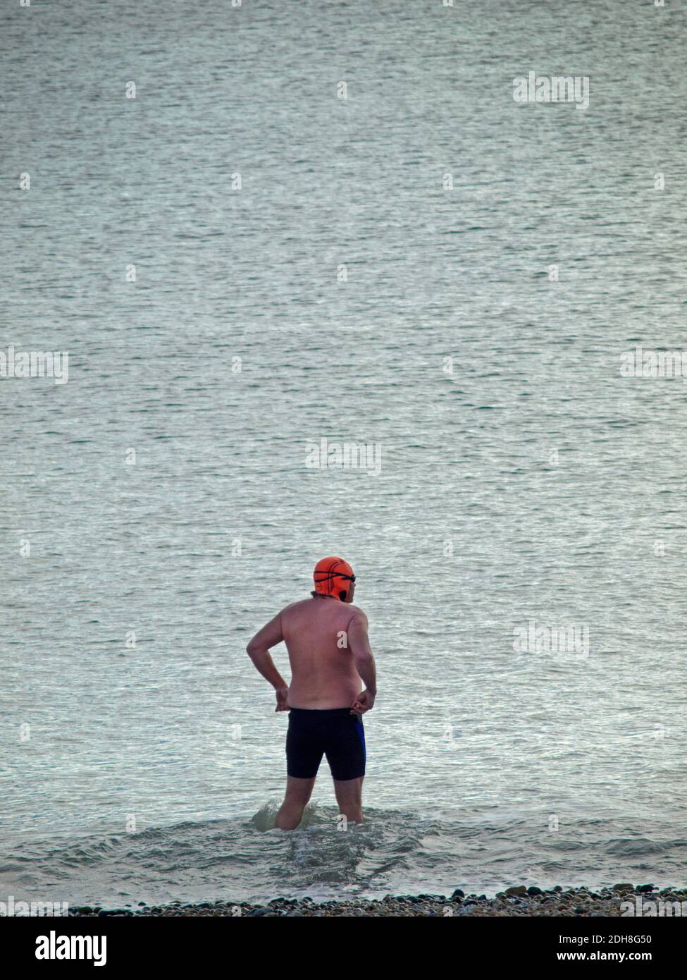 A swimmer enters the sea at Brighton, England Stock Photo