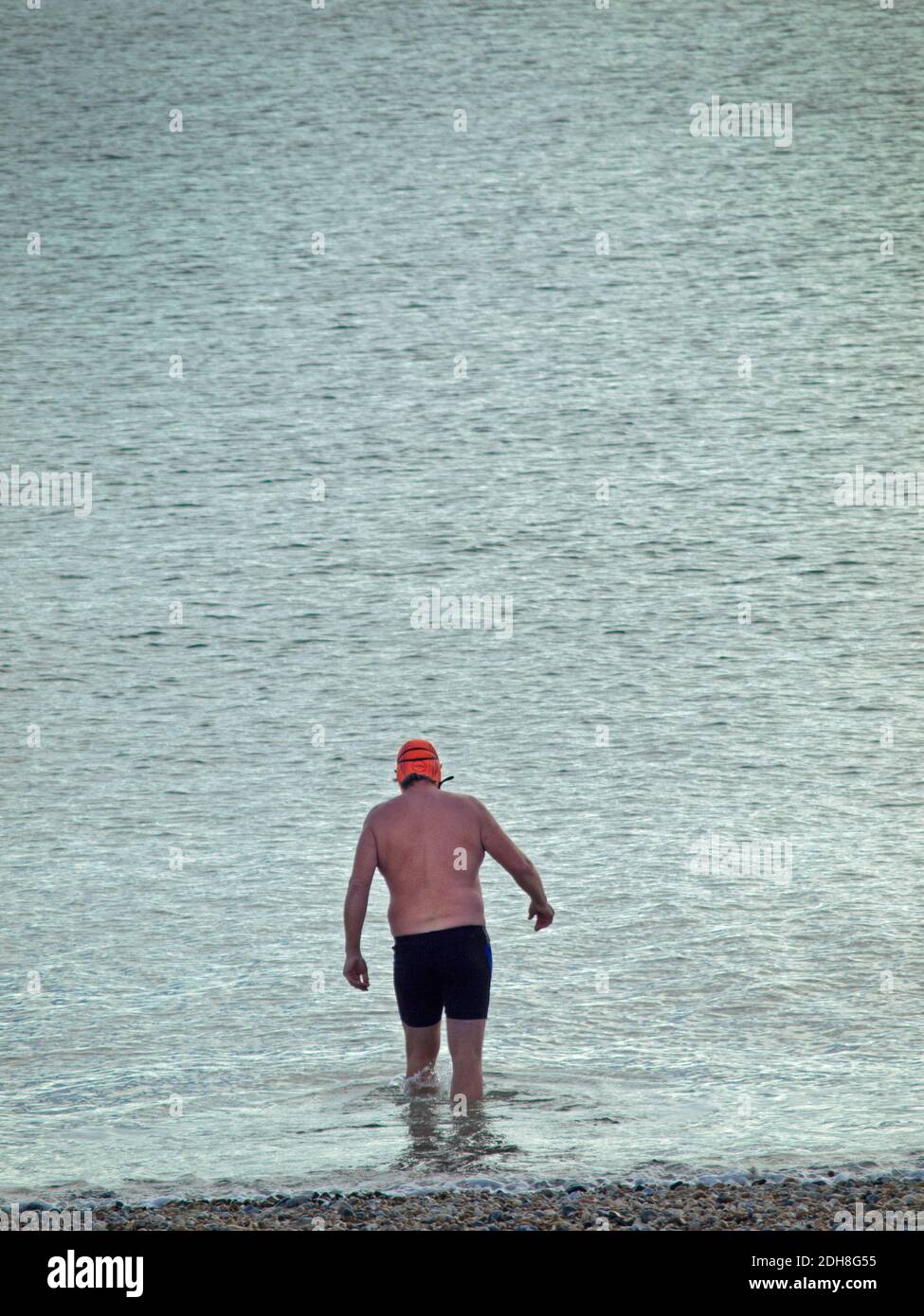 A swimmer enters the sea at Brighton, England Stock Photo