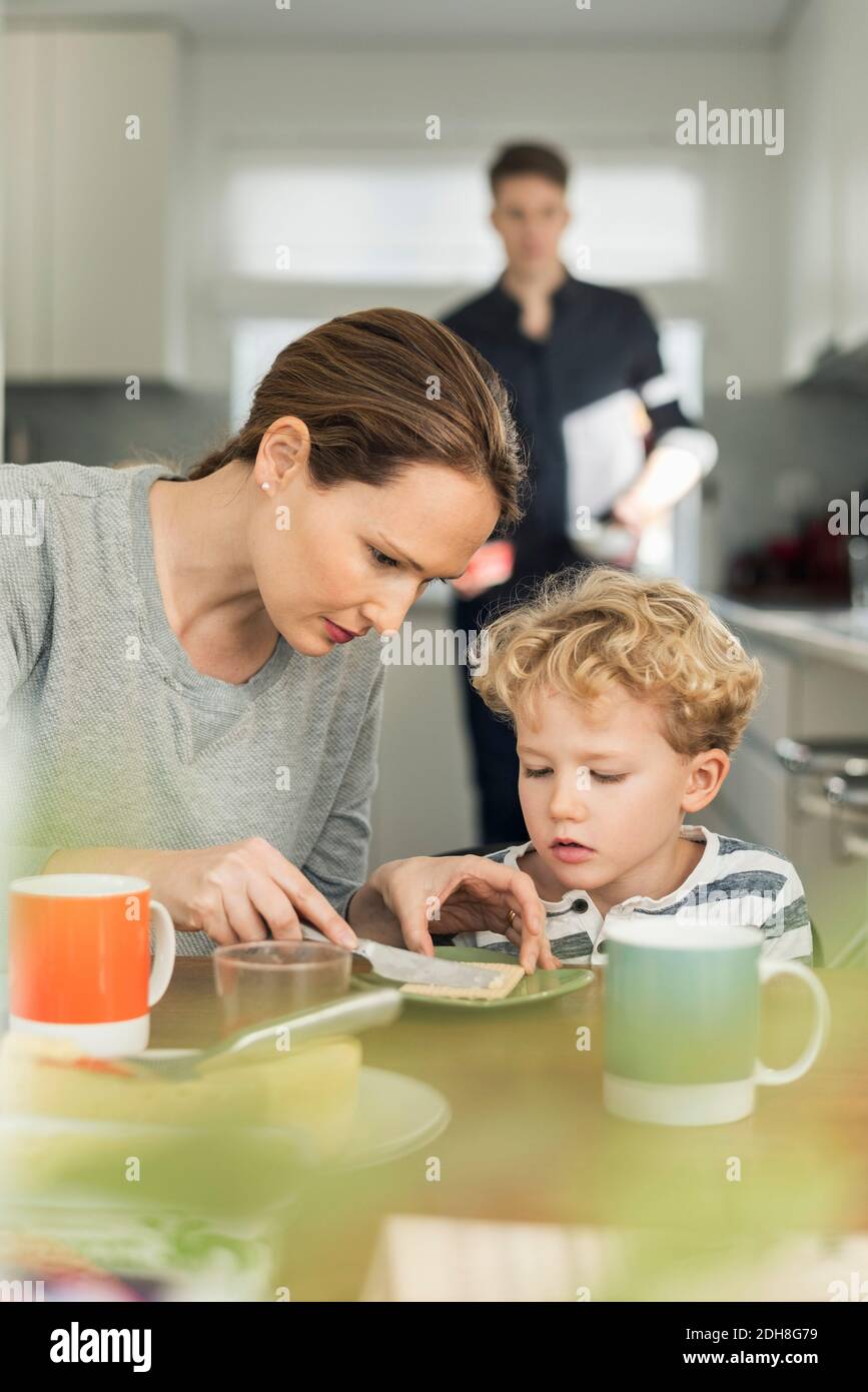 Woman making breakfast in living room at home Stock Photo