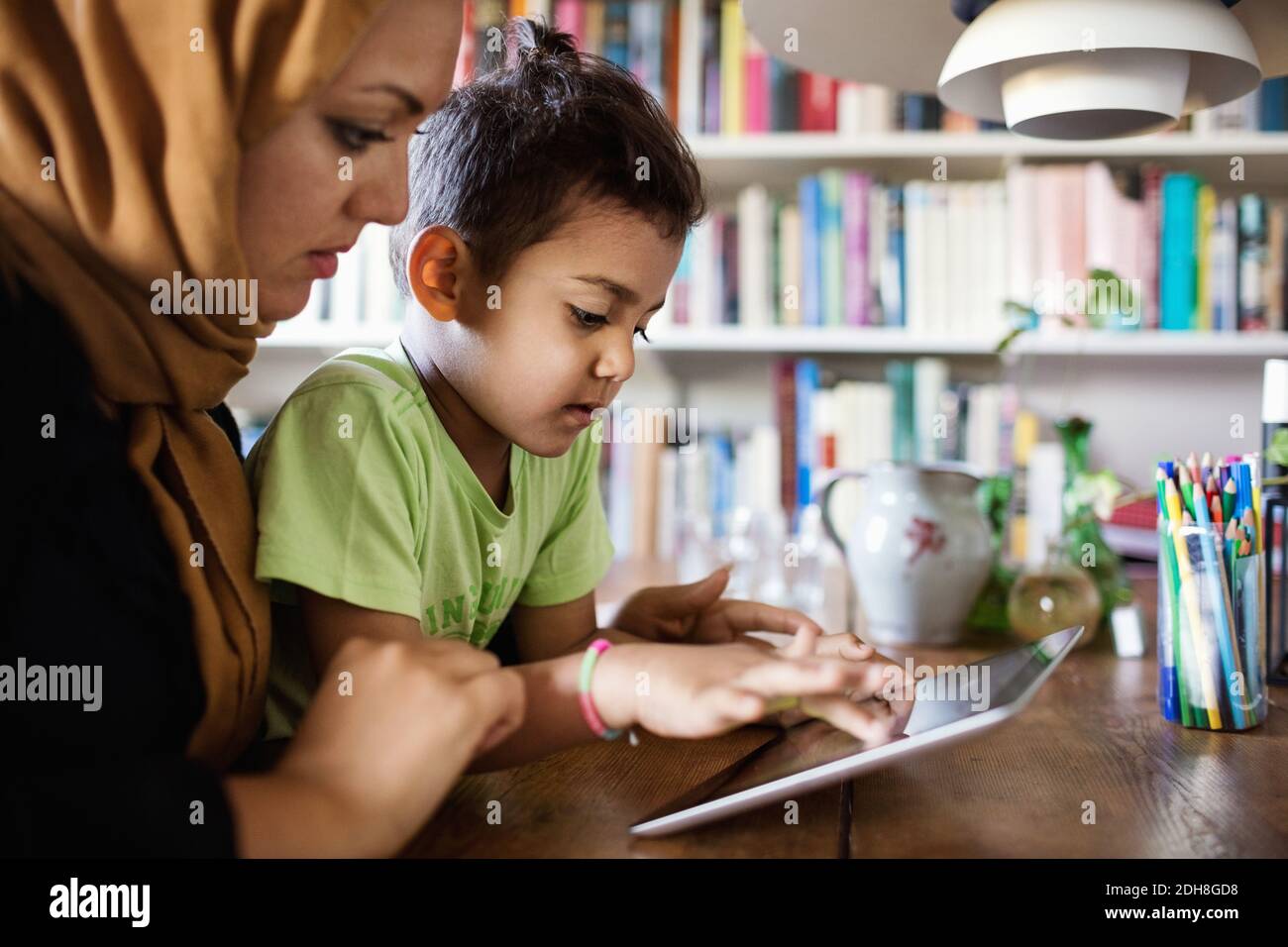 Mother and son using digital tablet at table Stock Photo