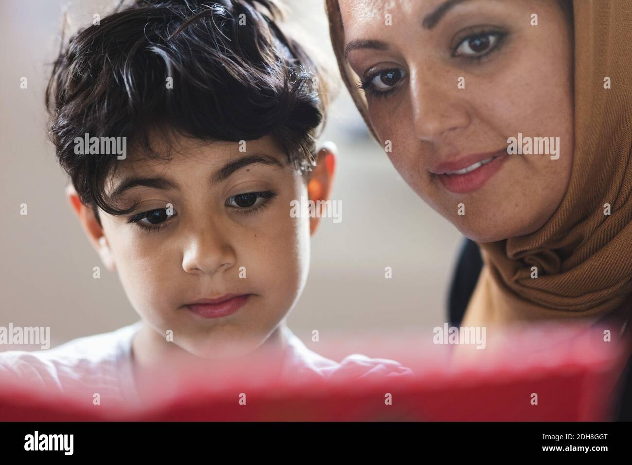 Mother and son reading book at home Stock Photo