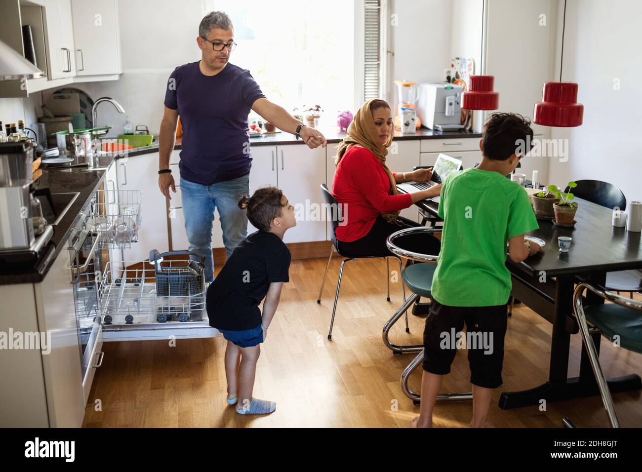 Family of four in brightly lit kitchen Stock Photo