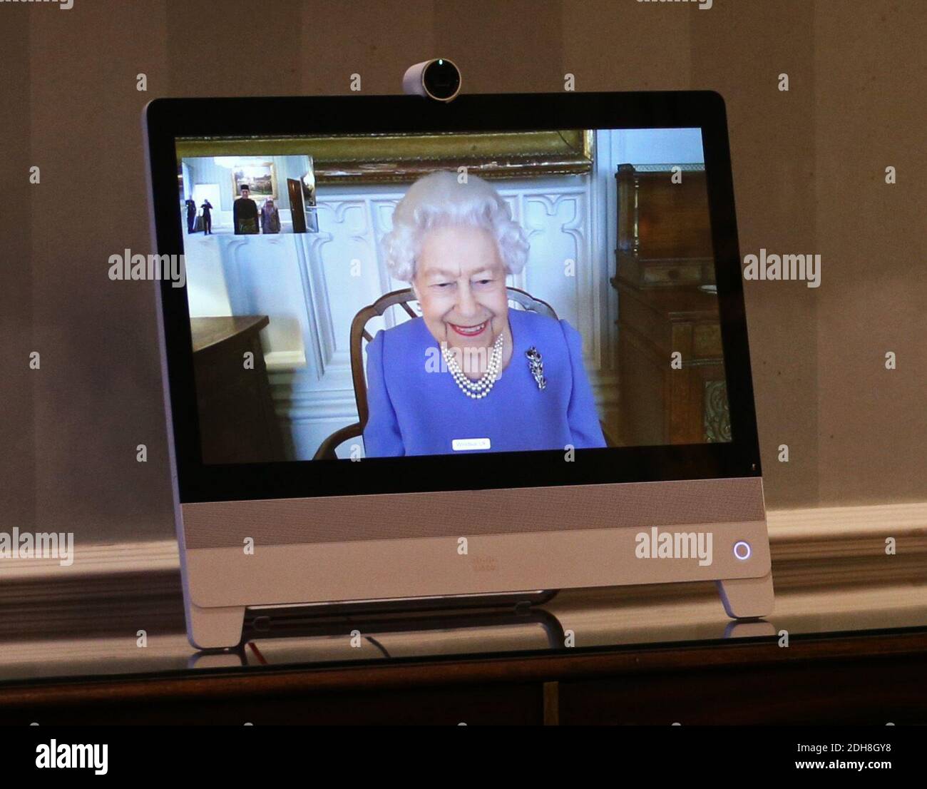 Queen Elizabeth II appears on a screen by videolink from Windsor Castle, where she is in residence, during a virtual audience to receive His Excellency the High Commissioner for Brunei Darussalam First Admiral Pengiran Dato Seri Pahlawan Norazmi bin Pengiran Haji Muhammad and his wife, Pg Datin Noralam binti Pg Hj Kahar, who were at London's Buckingham Palace. Stock Photo