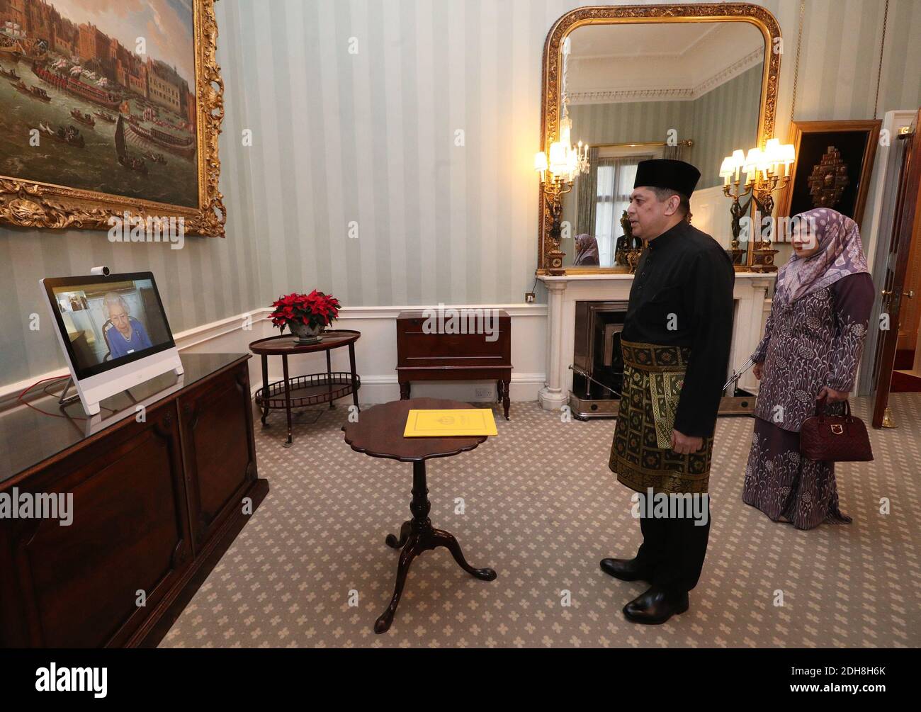 Queen Elizabeth II appears on a screen by videolink from Windsor Castle, where she is in residence, during a virtual audience to receive His Excellency the High Commissioner for Brunei Darussalam First Admiral Pengiran Dato Seri Pahlawan Norazmi bin Pengiran Haji Muhammad and his wife, Pg Datin Noralam binti Pg Hj Kahar, who were at London's Buckingham Palace. Stock Photo