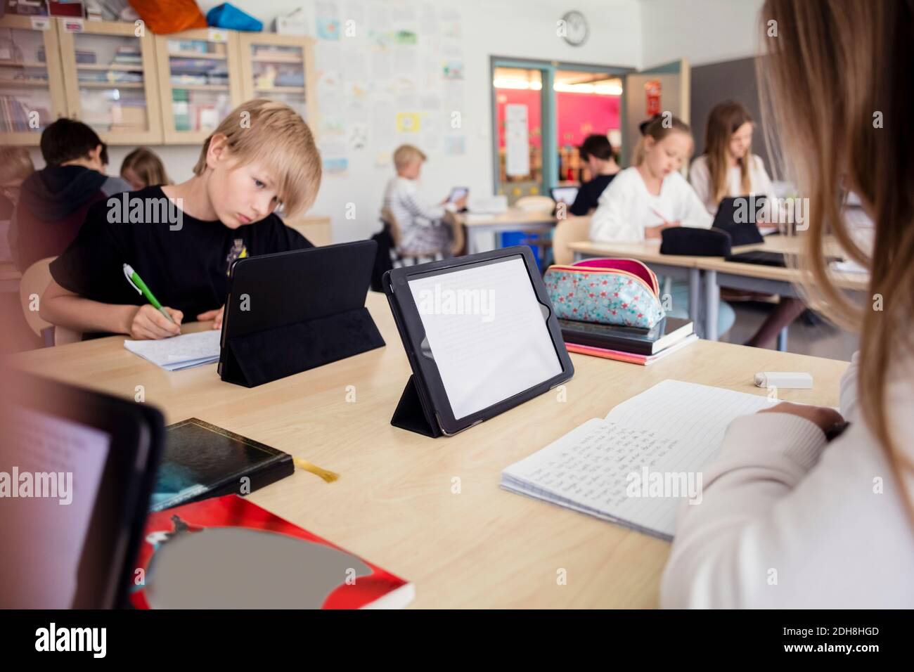 High school students learning through digital tablets in classroom