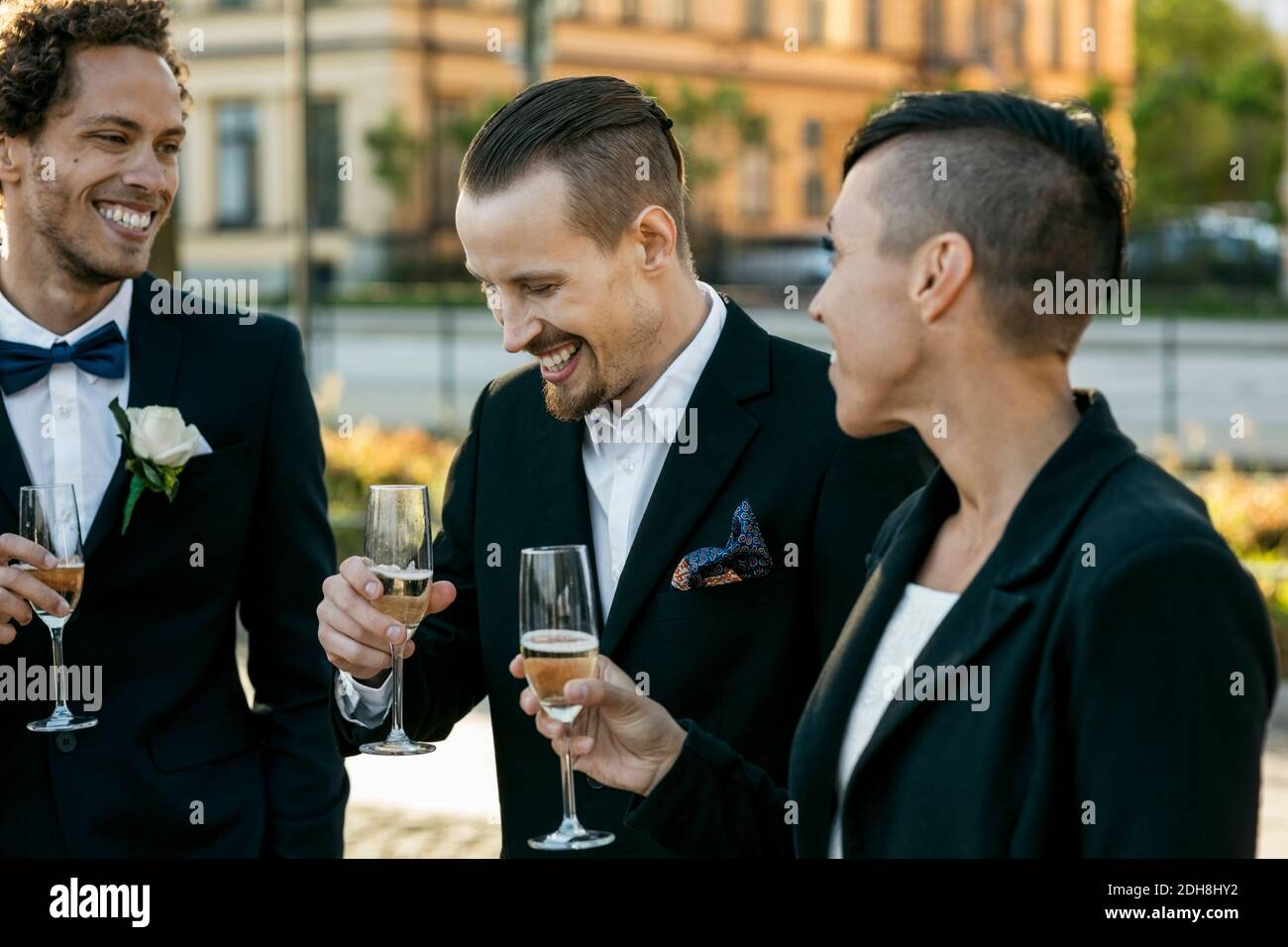 Happy friends with champagne during wedding ceremony Stock Photo
