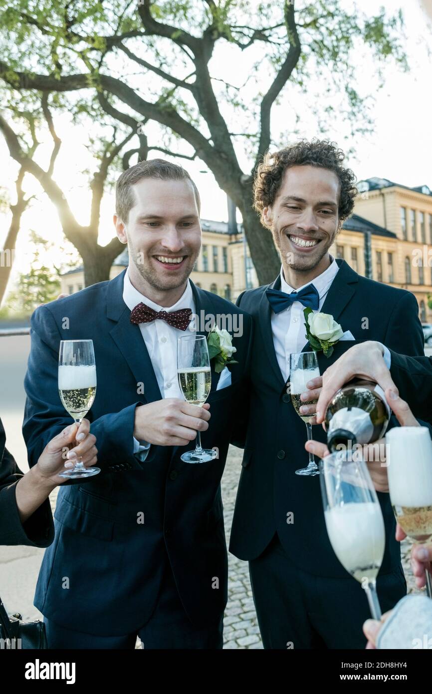 Cheerful friends with champagne during wedding ceremony Stock Photo