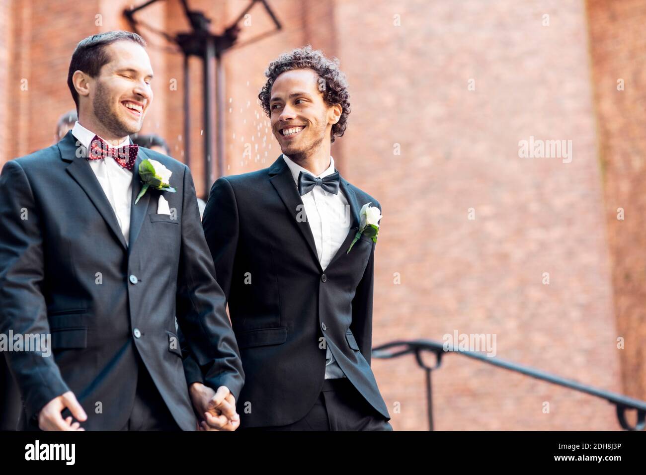 Low angle view of happy gay couple walking while holding hands Stock Photo