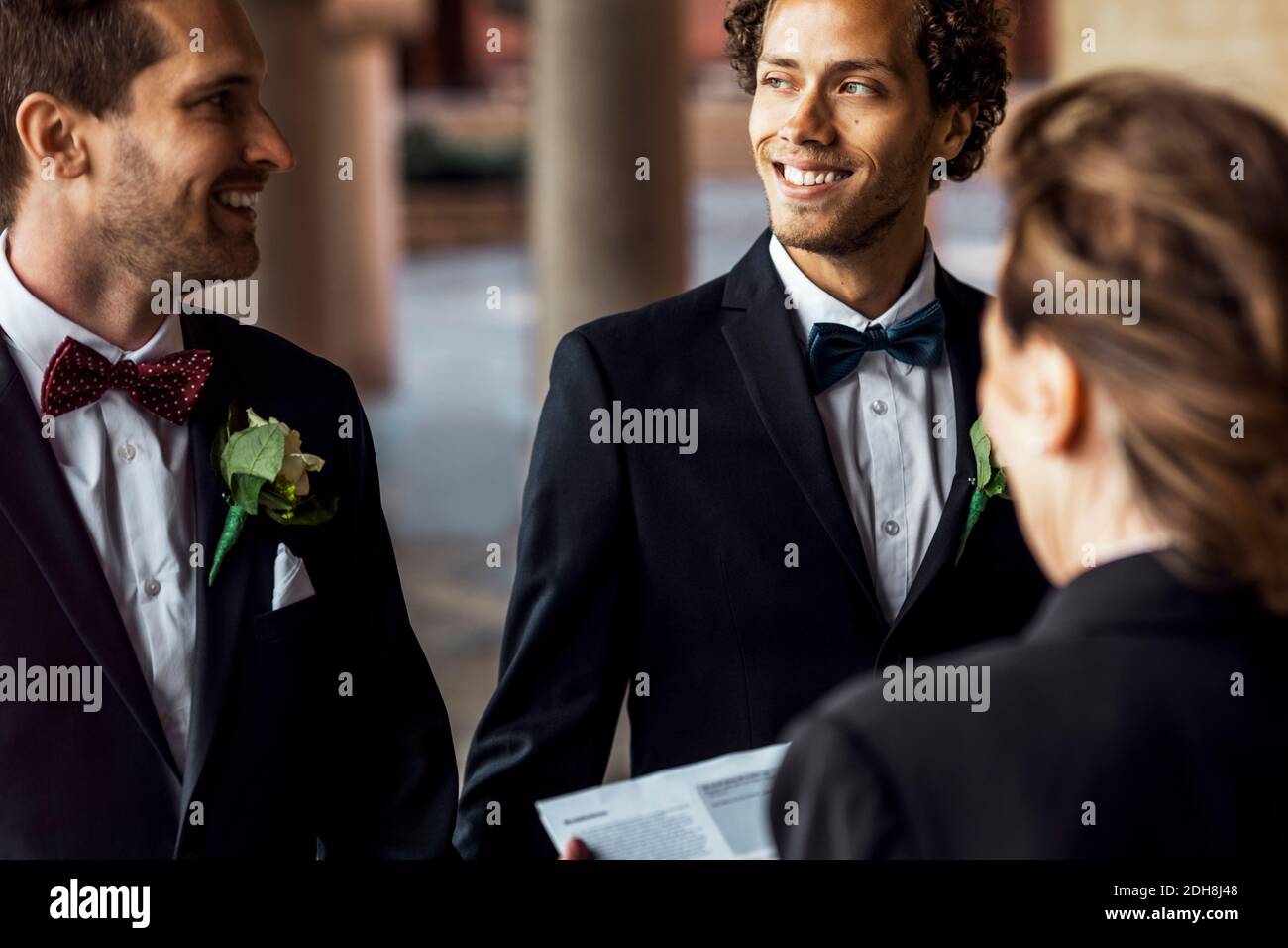 Rear view of priest in front of happy gay couple Stock Photo