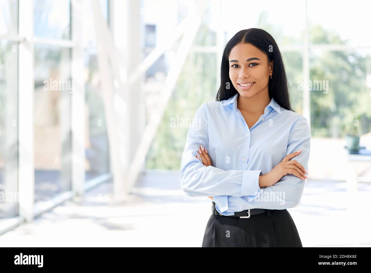 Smiling confident black businesswoman posing in a modern office with ...