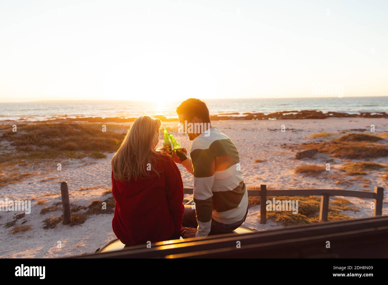 Couple drinking at the sunset beach Stock Photo - Alamy