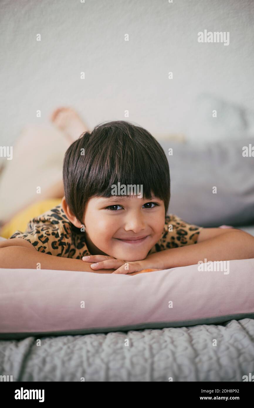 Portrait of smiling girl lying on sofa at home Stock Photo - Alamy