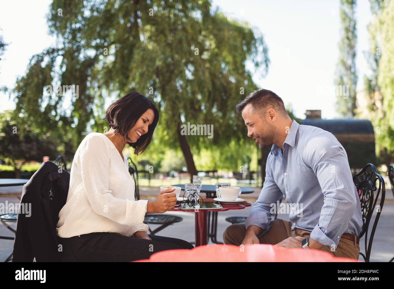 Business colleagues using digital tablet at sidewalk cafe Stock Photo