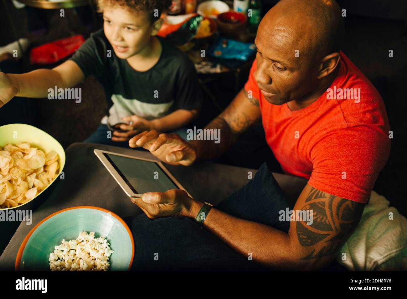High angle view of man using digital tablet by boy during sporting event Stock Photo